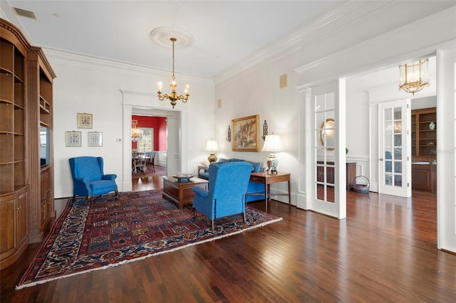 living room featuring crown molding, french doors, a chandelier, and dark hardwood / wood-style floors