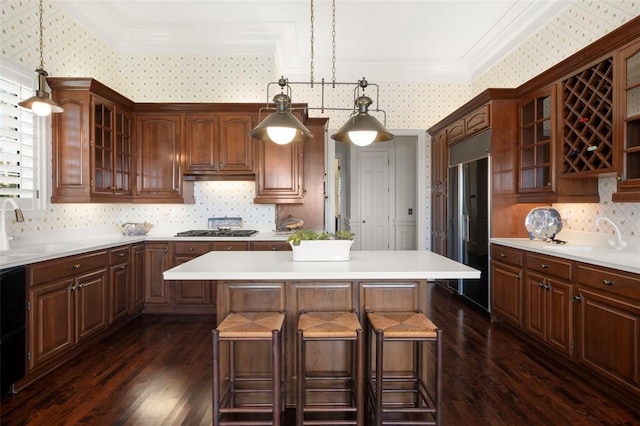 kitchen with sink, a center island, dark hardwood / wood-style flooring, built in refrigerator, and decorative light fixtures