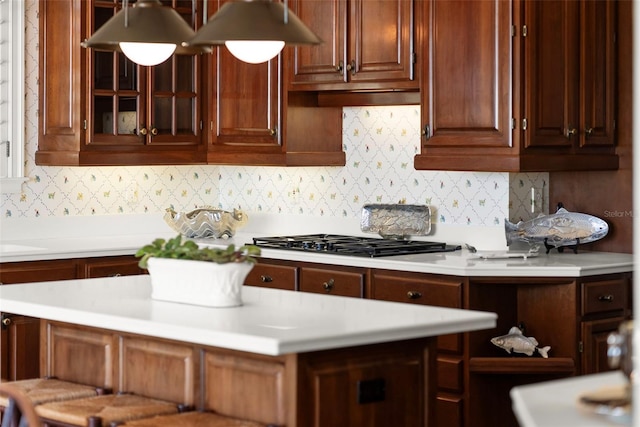 kitchen with stainless steel gas stovetop, sink, and backsplash