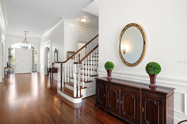 foyer with ornamental molding and dark wood-type flooring