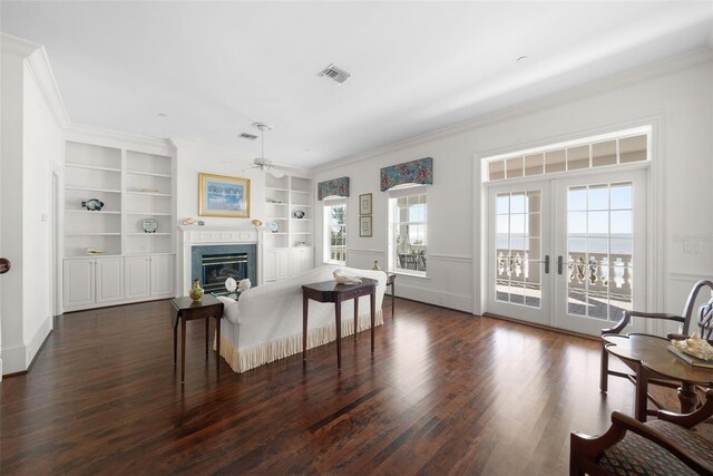 living room with french doors, dark hardwood / wood-style flooring, ceiling fan, crown molding, and built in features