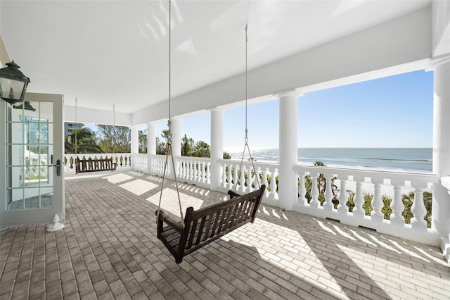 view of patio / terrace with a view of the beach and a water view