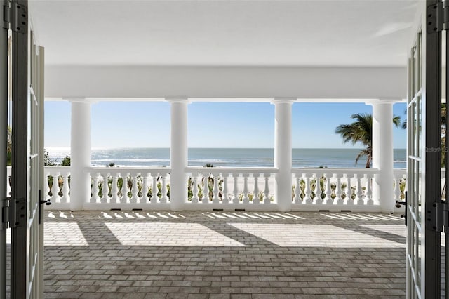 view of patio / terrace with a water view and a beach view