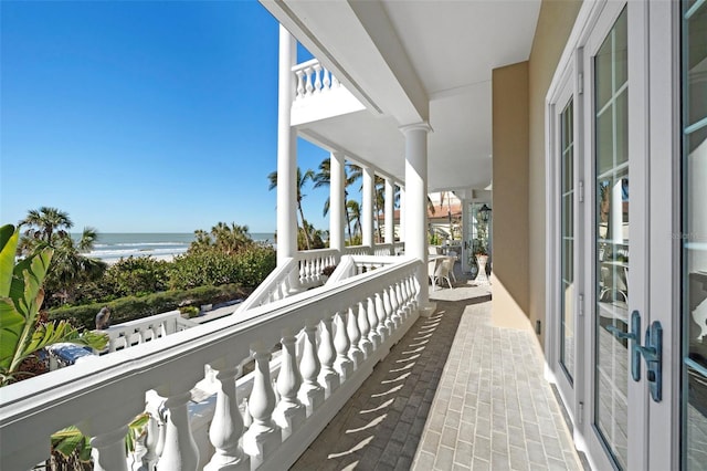 balcony featuring a water view and a beach view