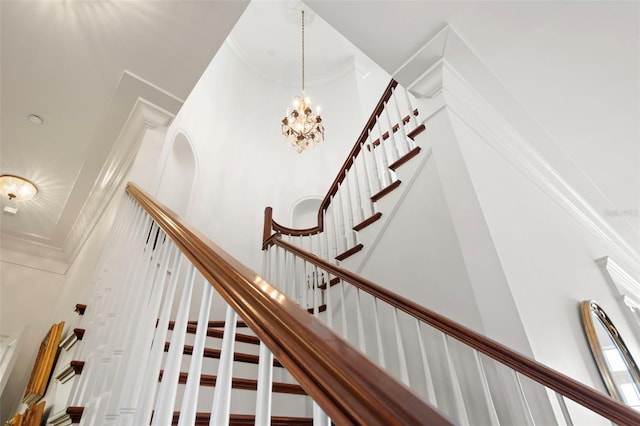 staircase featuring a high ceiling and a notable chandelier