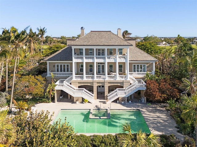 rear view of house featuring a balcony and a patio