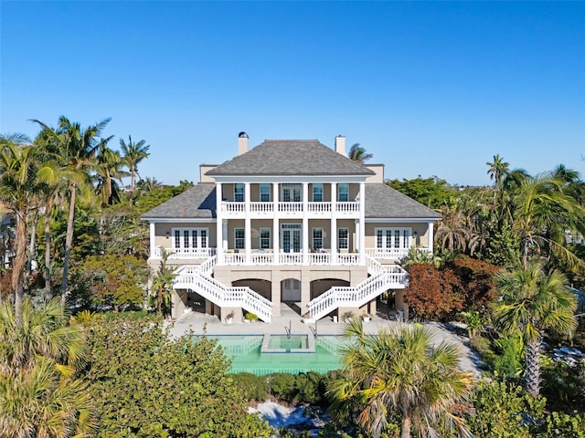 back of property with a balcony and a patio area