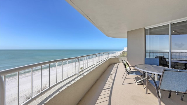 balcony featuring a water view and a view of the beach