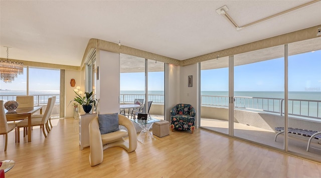 sunroom / solarium featuring plenty of natural light, a water view, and a notable chandelier