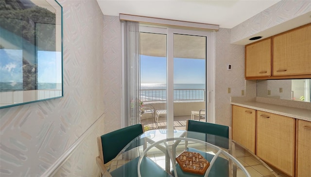 tiled dining room with plenty of natural light and a water view