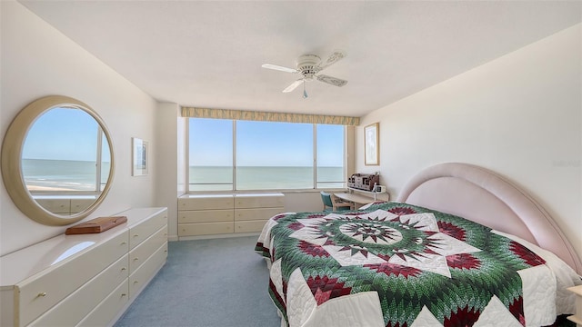 bedroom featuring ceiling fan, a water view, and light carpet