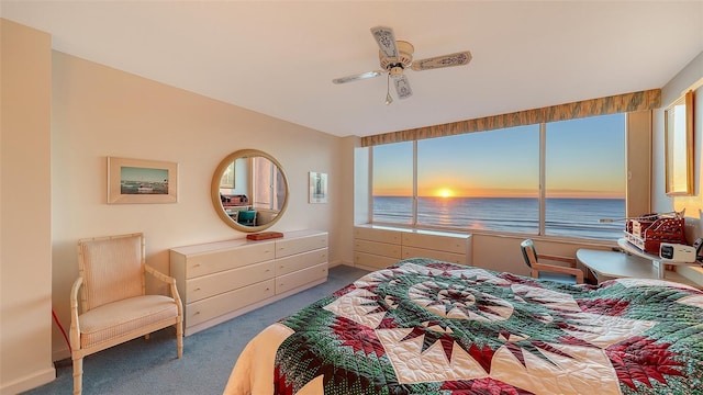 carpeted bedroom featuring ceiling fan, a water view, and multiple windows