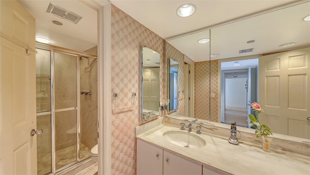 bathroom featuring an enclosed shower, vanity, and toilet