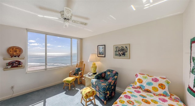 bedroom featuring carpet flooring, ceiling fan, and a water view