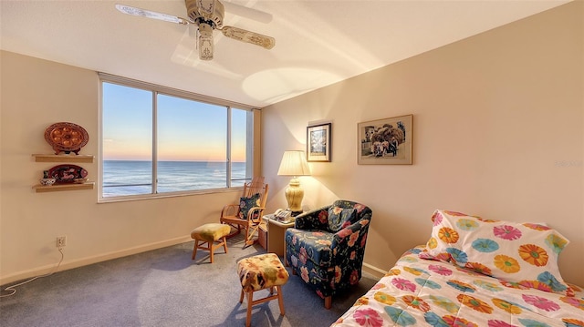 carpeted bedroom featuring ceiling fan and a water view