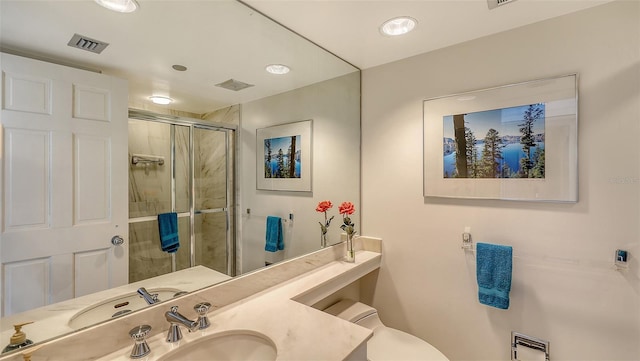 bathroom with vanity, toilet, and a shower with shower door