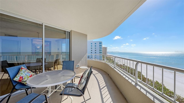 balcony featuring a beach view and a water view