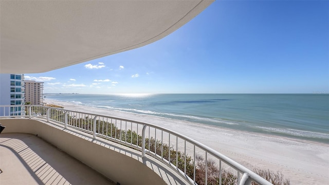 balcony featuring a beach view and a water view