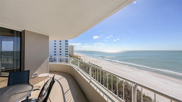 balcony with a water view and a view of the beach