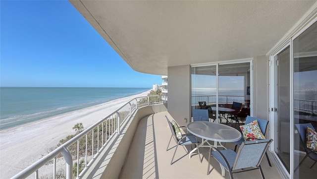 balcony with a water view and a beach view