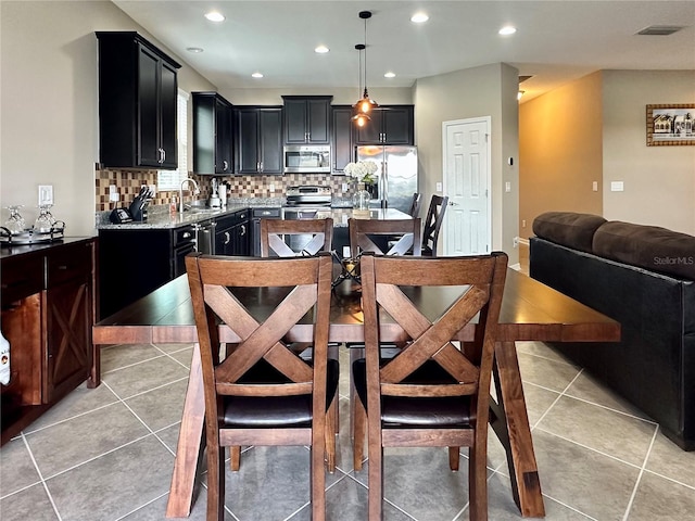 kitchen featuring sink, stainless steel appliances, decorative light fixtures, decorative backsplash, and light tile patterned floors