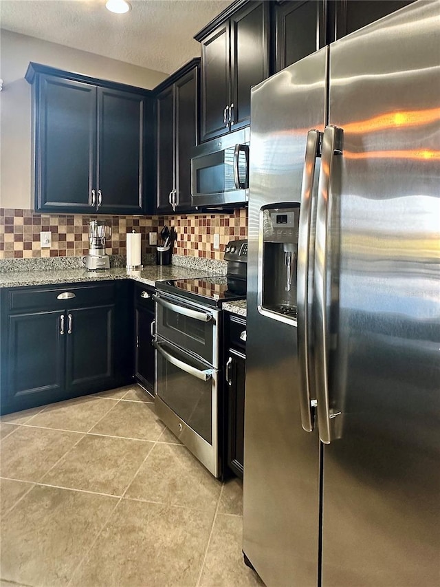 kitchen featuring light stone counters, stainless steel appliances, and tasteful backsplash