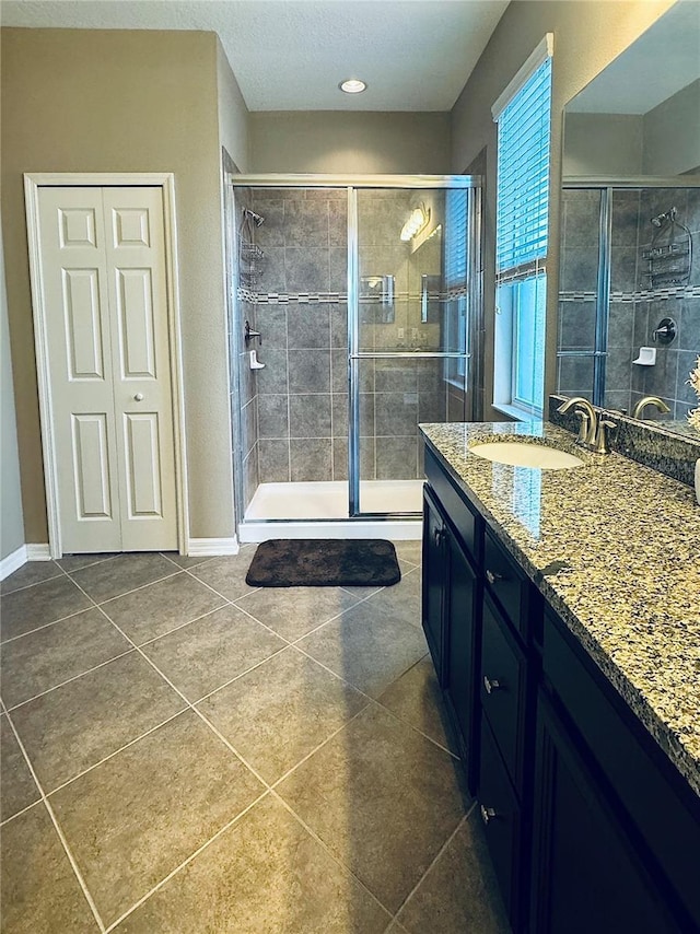 bathroom with tile patterned flooring, vanity, and an enclosed shower