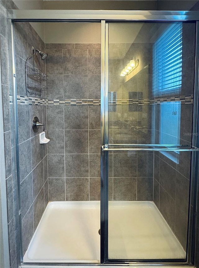 bathroom featuring a shower with door