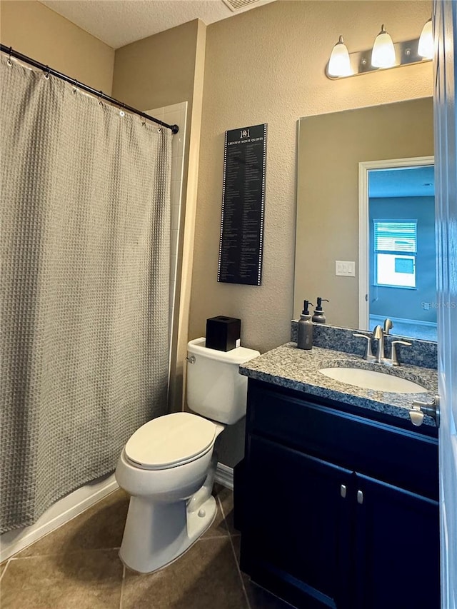 bathroom featuring tile patterned floors, vanity, toilet, and a textured ceiling