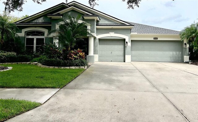 ranch-style home featuring a front yard and a garage