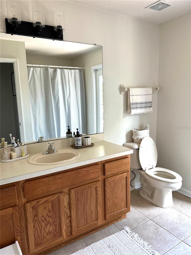 bathroom featuring toilet, tile patterned floors, and vanity