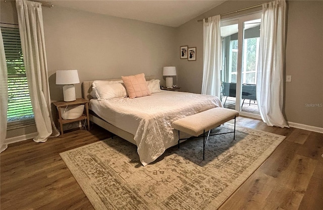 bedroom featuring dark hardwood / wood-style flooring, access to outside, and vaulted ceiling