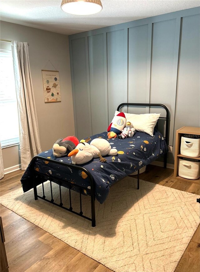 bedroom featuring a textured ceiling and light hardwood / wood-style flooring