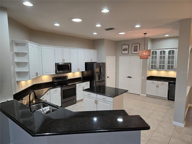 kitchen featuring sink, white cabinets, hanging light fixtures, and appliances with stainless steel finishes