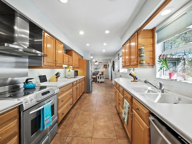 kitchen featuring light tile patterned flooring, appliances with stainless steel finishes, sink, and wall chimney range hood