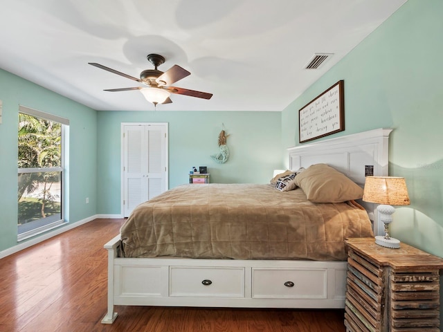 bedroom featuring a closet, dark hardwood / wood-style floors, and ceiling fan