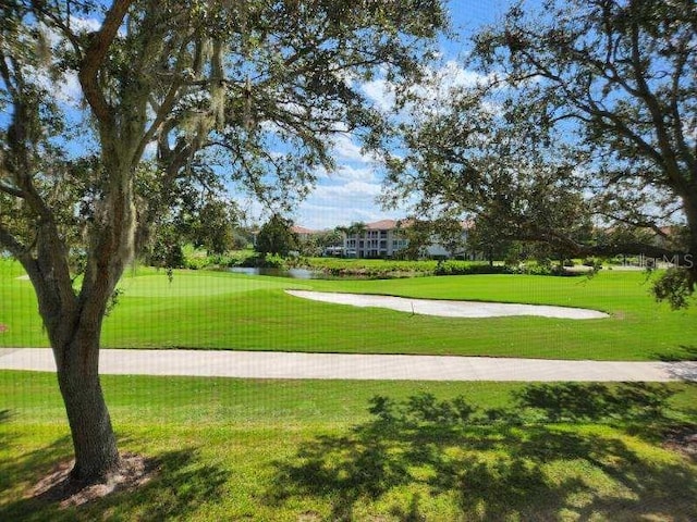 surrounding community featuring a lawn and a water view