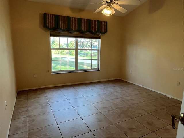 spare room with ceiling fan and light tile patterned flooring