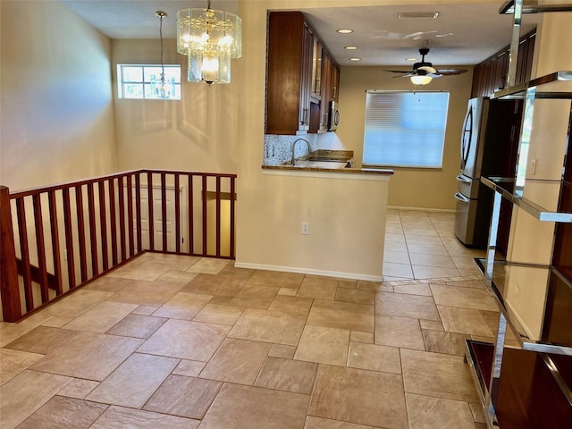 kitchen featuring range, ceiling fan with notable chandelier, hanging light fixtures, and sink