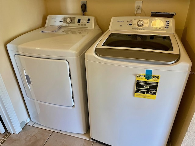 laundry room featuring separate washer and dryer and light tile patterned floors