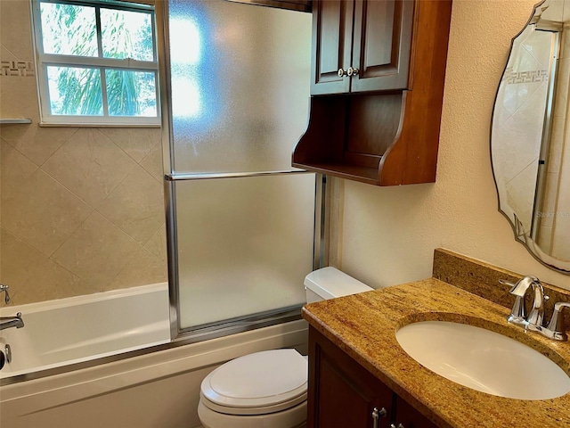 full bathroom featuring vanity, toilet, and bath / shower combo with glass door