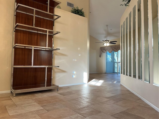 interior space with ceiling fan and a towering ceiling