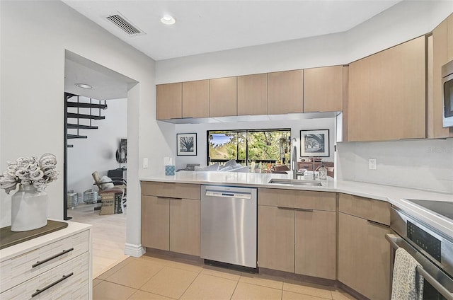 kitchen featuring sink, stainless steel appliances, light brown cabinetry, and light hardwood / wood-style flooring