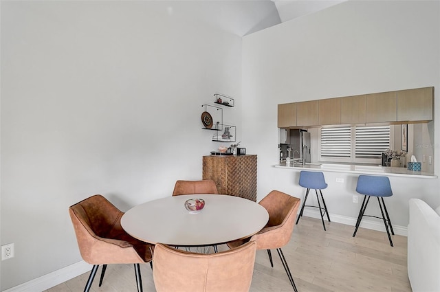 dining space featuring light hardwood / wood-style flooring and vaulted ceiling