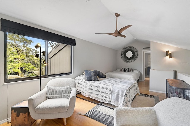 bedroom with ceiling fan, wood-type flooring, and vaulted ceiling