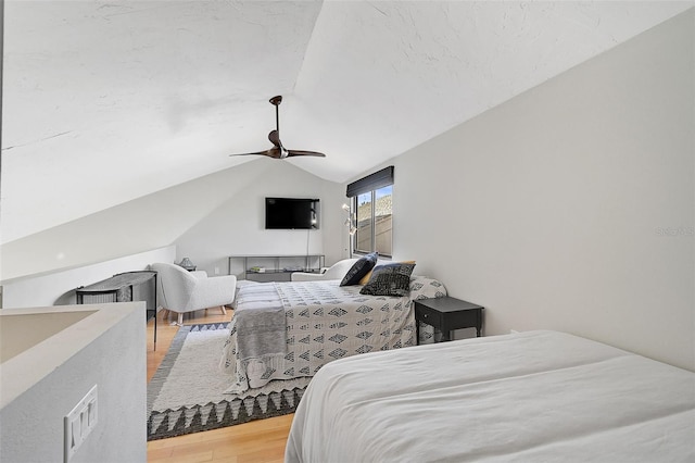 bedroom with wood-type flooring, vaulted ceiling, and ceiling fan