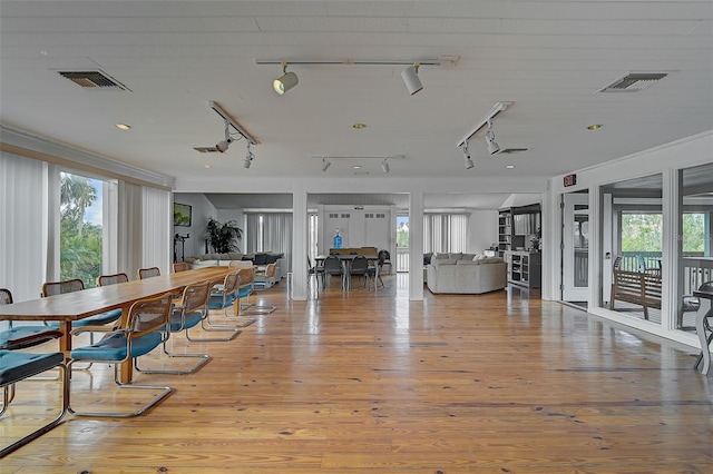 dining room with light wood-type flooring and rail lighting