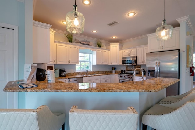 kitchen featuring white cabinets, decorative light fixtures, kitchen peninsula, and stainless steel appliances