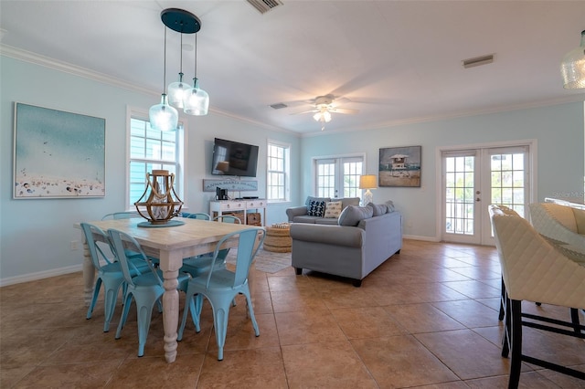 tiled dining area featuring french doors, ceiling fan, and crown molding