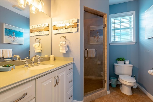 bathroom featuring tile patterned floors, a shower with door, vanity, and toilet